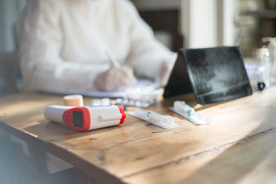 Healthcare worker organizing medical supplies on a desk indoors.
